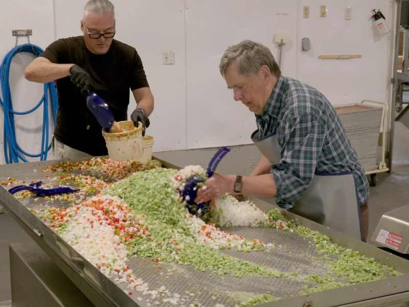 Volunteers moving diced vegetables.