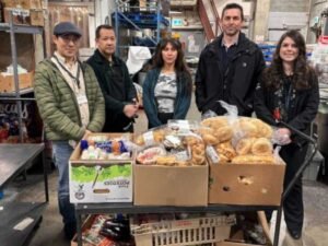 Dan's legacy and Pattison Food Group staff in front of boxes of donated food.