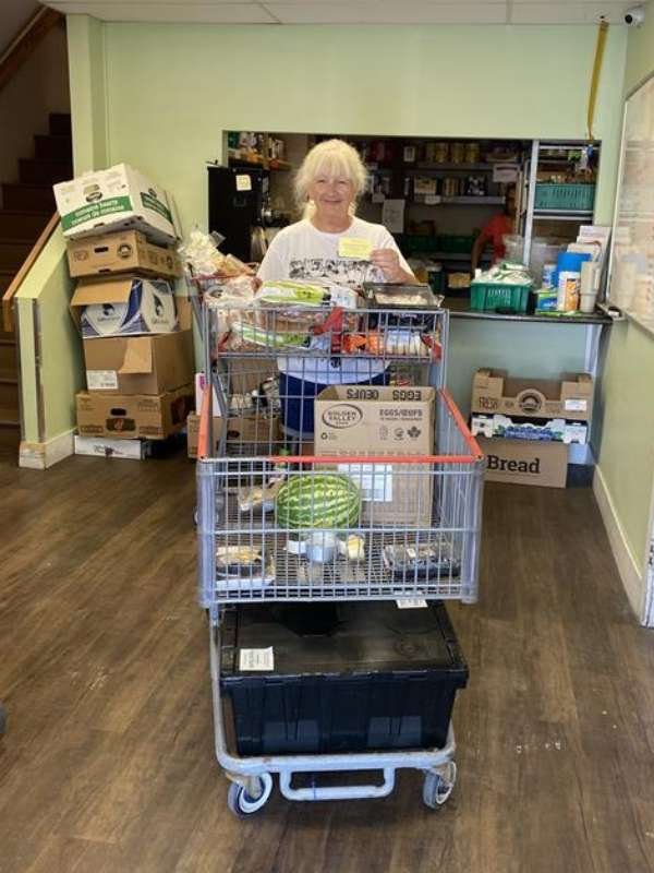 2 Archway food bank volunteers preparing to serve food.