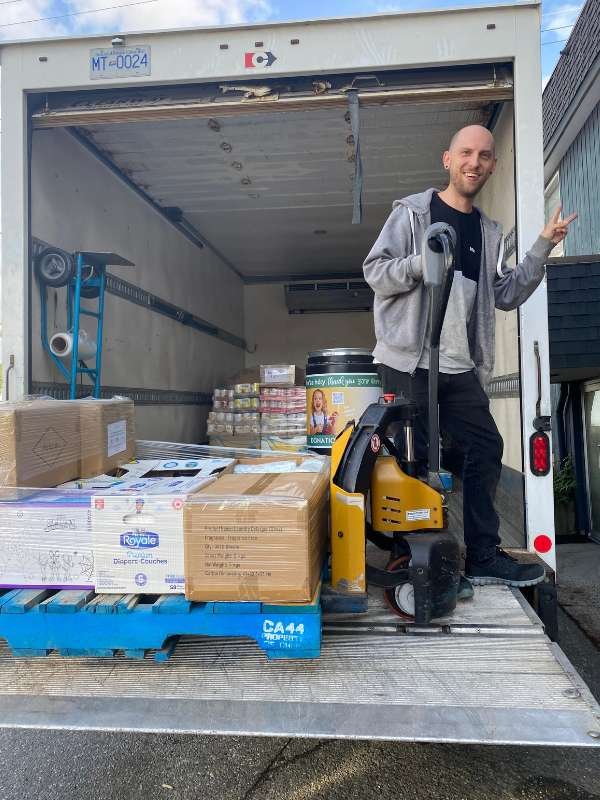 4 Archway food bank volunteers unloading food.